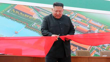 Nordkoreas Machthaber Kim Jong Un schneidet in einer Düngemittelfabrik ein Band durch.