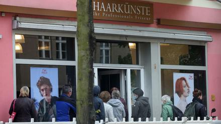 Ein lange Schlange hat sich vor einem Friseurladen in Berlin-Köpenick gebildet.