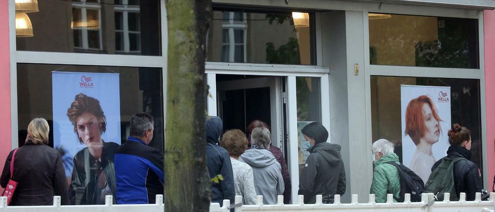 Ein lange Schlange hat sich vor einem Friseurladen in Berlin-Köpenick gebildet.