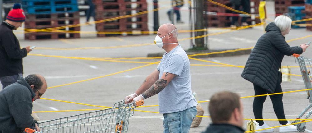 Anstehen mit Schutzmasken und Abstand im britischen Loughborough