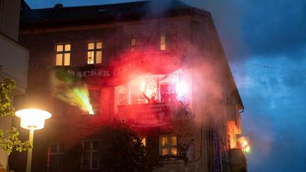 Kleines Finale: Linksautonome zünden auf einem Balkon eines Hauses in der Rigaer Straße bengalische Feuer.