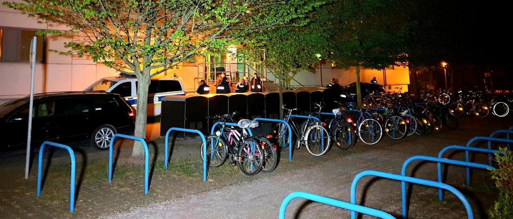 Polizisten stehen vor der Gemeinschaftsunterkunft für Asylbewerber in Zehdenick, in der am Abend ein Mann getötet wurde.