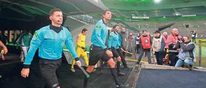 Hereinspaziert: Das Schiedsrichtergespann um Deniz Aytekin (Mitte) betritt beim ersten Geisterderby zwischen Gladbach und Köln die Bühne.