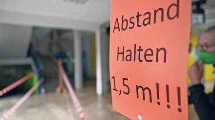 In einer Schule fordert ein Schild Schüler und Lehrkräfte dazu auf, 1,5 Meter Abstand zu halten. Das Verb halten ist mit einem großen H geschrieben.