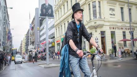 Juha Järvinen, Teilnehmer des Experiments Grundeinkommen in Finnland, fährt auf einem geliehenen Fahrrad am Checkpoint Charlie vorbei. 
