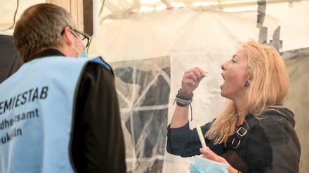 Eine junge Frau führt unter der Anleitung von Thomas Linhart, Arzt, im Corona-Abstrich-Zentrum (CAZ) Neukölln, ein Selbsttest durch.