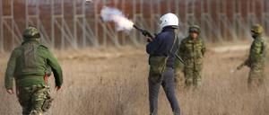 Ein griechischer Soldat feuert eine Tränengaspatrone ab.