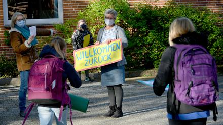 Eine Lehrerin begrüßt einer Grundschule in Schleswig-Holstein begrüßt ihre Schüler. Hier wurden die Schulen für die 4. Klassen an Grundschulen wieder geöffnet. 