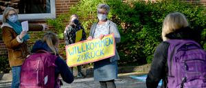 Eine Lehrerin begrüßt einer Grundschule in Schleswig-Holstein begrüßt ihre Schüler. Hier wurden die Schulen für die 4. Klassen an Grundschulen wieder geöffnet.
