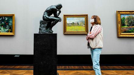 Eine Besucherin der Alten Nationalgalerie schaut dem "Denker" des französischen Bildhauers Auguste Rodin beim Denken zu.