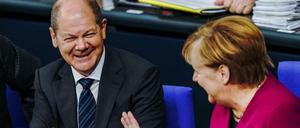 Olaf Scholz (SPD), Bundesfinanzminister, lacht neben Bundeskanzlerin Angela Merkel (CDU), im Bundestag vor der Corona-Krise ohne Abstand. 