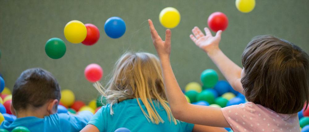 Kinder spielen in einem Bällebad in einer Kindertagesstätte.