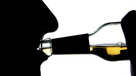 Die Silhouette eines Alkohol trinkenden Menschen. Einer Analyse der Krankenkasse Barmer zufolge nimmt die Zahl alkoholabhängiger Menschen leicht zu.