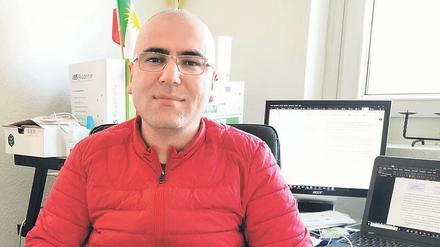 Salar Ossi sitzt im Homeoffice auf einem Bürostuhl vor zwei Computerbildschirmen.