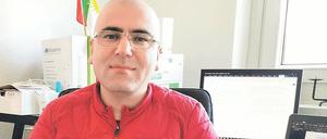 Salar Ossi sitzt im Homeoffice auf einem Bürostuhl vor zwei Computerbildschirmen.