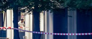 Ein Mitarbeiter eines Sicherheitsdienstes betritt in einem Schutzanzug eine Flüchtlingsunterkunft in St. Augustin. 