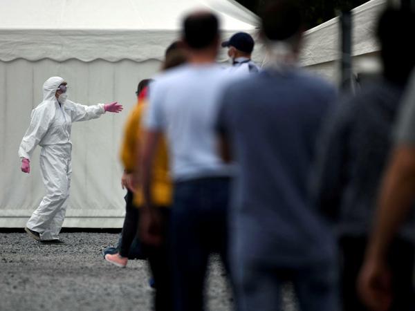 Mitarbeiter in einem "Westfleisch"-Betrieb warten auf ihren Coronatest.