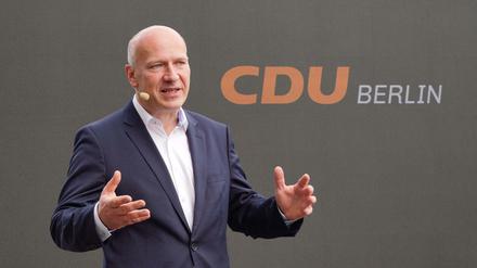 Kai Wegner, Landesvorsitzender der Berliner CDU vor dem neuen Logo - jetzt in orange auf schwarzem Grund.