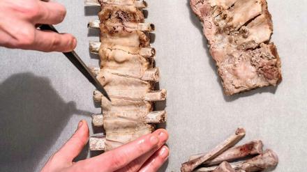 Um die Knochen aus dem gekochten Rippenstück zu lösen, einfach die dünne Haut auf der Rückseite einritzen und die Knochen herausziehen.