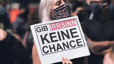 Eine Frau mit einem Protestschild bei einer Demonstration.