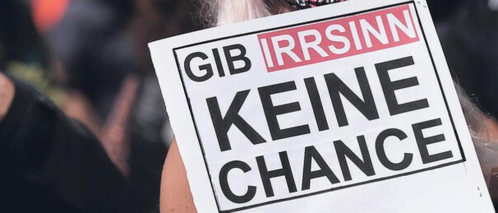 Eine Frau mit einem Protestschild bei einer Demonstration.