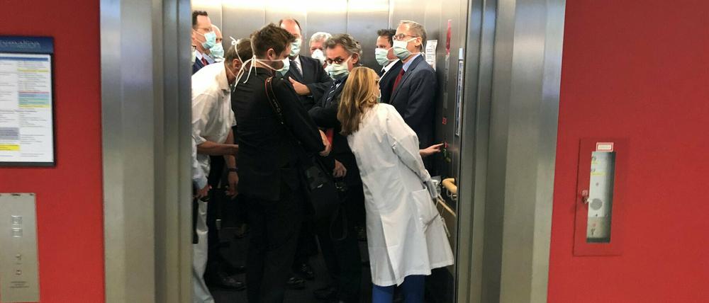 In der Uniklinik Gießen drängen sich Gesundheitsminister Jens Spahn (CDU, l), und Hessens Ministerpräsident Volker Bouffier (CDU, M) mit Begleitern in einem Fahrstuhl.