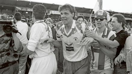 Es ist vollbracht: Herthas Kapitän Dirk Greiser (Mitte) und mitgereiste Fans bejubeln nach dem Spiel bei Alemannia Aachen den vorzeitigen Aufstieg in die Bundesliga.