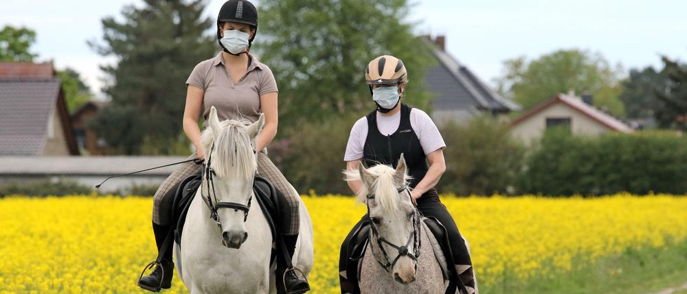 Schutz muss sein: Wer reiten geht, wie diese beiden Sportsfreundinnen in Brandenburg, sollte sich natürlich auch an die Hygieneregeln halten.