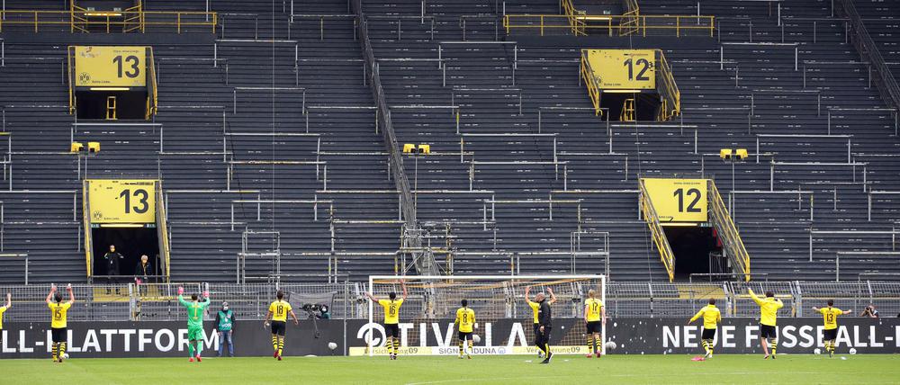 Ein Dank an die, die nicht da sind: Dortmunds Spieler nach dem Sieg vor der Südtribüne. 