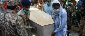 Soldaten und Angehörige tragen Opfer des Flugzeugabsturz in Karachi zu Grabe.