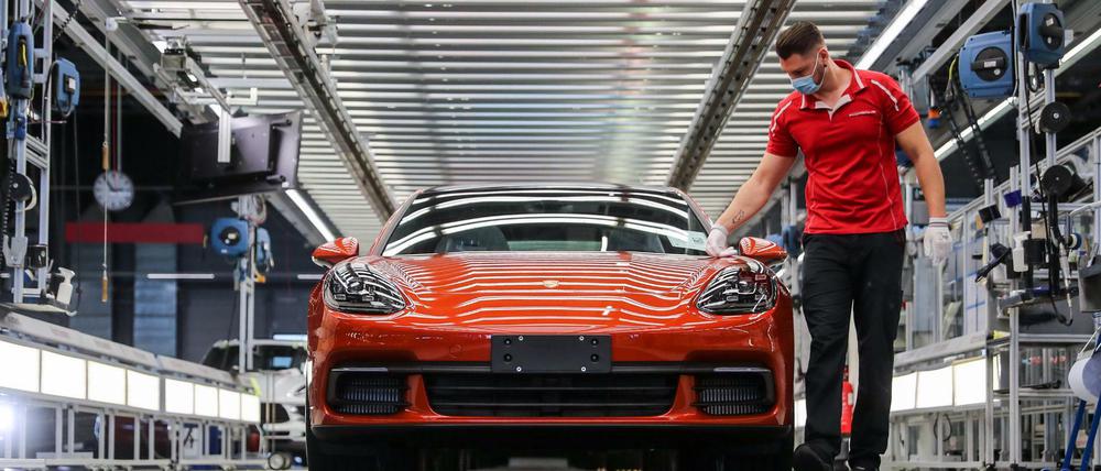 Ein Mitarbeiter von Porsche führt im Werk in Leipzig die finale Qualitätskontrolle an einem Panamera durch.