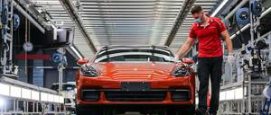 Ein Mitarbeiter von Porsche führt im Werk in Leipzig die finale Qualitätskontrolle an einem Panamera durch.