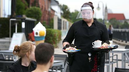 Symbolbild: Bedienung mit Gesichtsschutz.