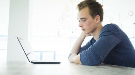 Ein Student sitzt vor seinem Laptop.