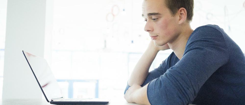 Ein Student sitzt vor seinem Laptop.