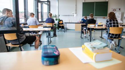 Schüler einer 10. Klasse in Baden-Württember sitzen an Einzeltischen in ihrer Klasse.