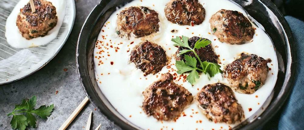 Auf dem Foto aus dem Kochbuch sitzen die Hackbällchen direkt im Joghurt, aber man kann auch einfach, wie im Rezept erwähnt, einen Extraklacks davon auf den Teller geben. 