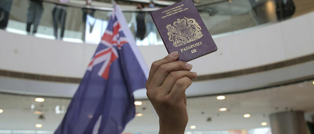Demonstranten halten während eines Protests gegen Chinas neues Sicherheitsgesetz für die Stadt Hongkong eine Fahne und einen britischen Pass in die Höhe. 