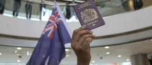 Demonstranten halten während eines Protests gegen Chinas neues Sicherheitsgesetz für die Stadt Hongkong eine Fahne und einen britischen Pass in die Höhe.