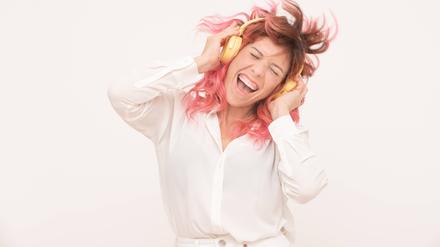 Voll aufgedreht. Frau hört tanzt zur Musik.