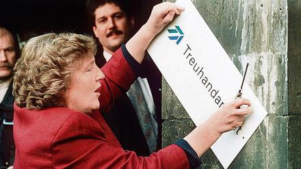 Die scheidende Präsidentin Birgit Breuel entfernt am Jahresende 1994 das Schild am Eingang der Treuhandanstalt in Berlin. 