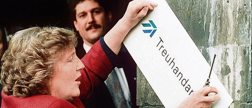 Die scheidende Präsidentin Birgit Breuel entfernt am Jahresende 1994 das Schild am Eingang der Treuhandanstalt in Berlin.