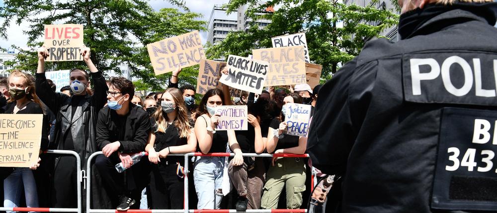Polizist beobachtet Anti-Rassismus-Demo auf dem Alexanderplatz in Berlin.