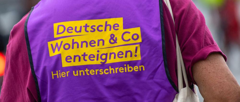 Ein Teilnehmer einer Demonstration in Berlin trägt eine Weste mit der Aufschrift "Deutsche Wohnen Co enteignen!"