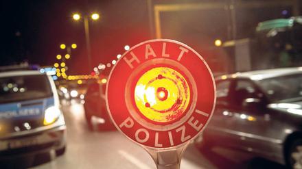 Ein Polizist stoppt am 18.09.2014 in Berlin auf der Autobahn 100 unweit der Aus- und Einfahrt Beusselstraße mit seiner Kelle einen Pkw. Beim bundesweiten Blitzer-Marathon geht die Polizei in der Hauptstadt an verschiedenen Kontrollstellen gegen Raser vor. Foto: Paul Zinken/dpa +++(c) dpa - Bildfunk+++