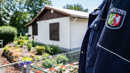 Ein Polizeibeamter vor der Gartenlaube, wo der Haupttäter Teile seiner Server-Anlage unterbrachte. 