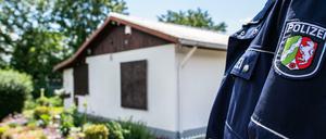 Ein Polizeibeamter vor der Gartenlaube, wo der Haupttäter Teile seiner Server-Anlage unterbrachte.