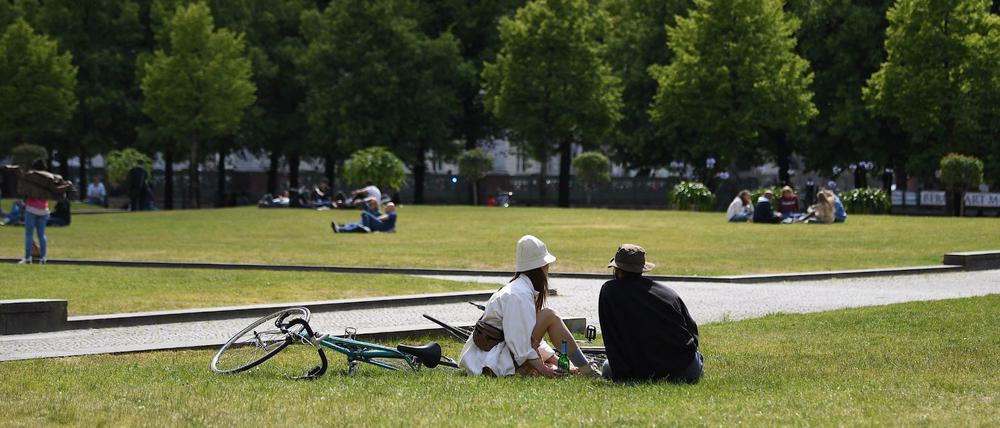Menschen genießen die Sonne im Lustgarten in Berlin.
