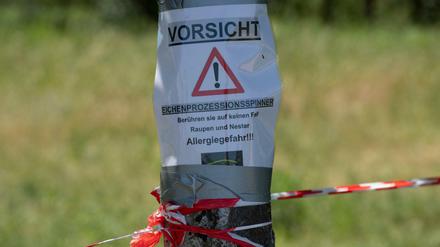 Auf einem Zettel wird im Erholungspark Marzahn vor dem Eichenprozessionsspinner gewarnt.