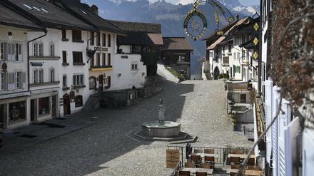 Häuser mit Restaurants, Läden und Herbergen stehen an der leeren Hauptstraße von Gruyeres, Schweiz, die sonst ein Touristenmagnet ist. 